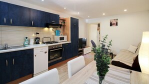 A modern kitchen with dark blue cabinets, a microwave, a toaster, and a sink. - Apartment 2178/55780 (Istria - Pula), 3000m from the beach (Pula)