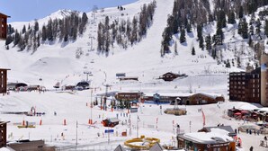 Une station de ski dotée d'un télésiège, de bâtiments et offrant un paysage enneigé.