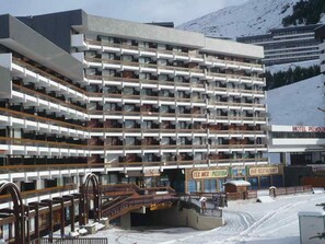 A multi-story hotel with balconies, a ski lift, and a mountain view. - Bright studio in Menuires, ski-in/ski-out, balcony (Les Menuires)
