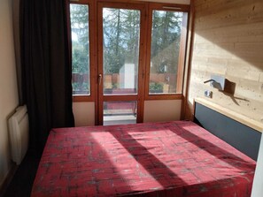 Ein Zimmer mit einem Bett, einem Fenster und einer Heizung.