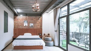 A bedroom with a large bed, a brick wall, a chandelier, and a view of the outdoors. - Mugen Town Residence (Zixing)