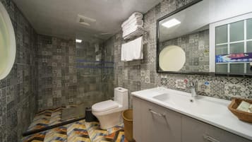 A bathroom with patterned tiles, a toilet, a sink, and a mirror.