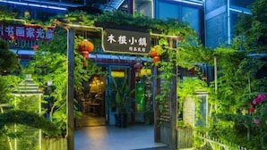 An entrance with a sign, surrounded by lush greenery and decorative lights. - Mugen Town Residence (Zixing)