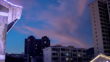 En stadsbild i skymningen med höga byggnader och en klar himmel.