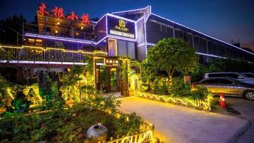Un hotel de diseño moderno, con una entrada destacada y un jardín bien iluminado.