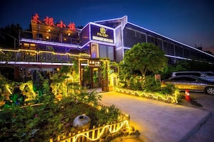 Un hotel de diseño moderno, con una entrada destacada y un jardín bien iluminado.