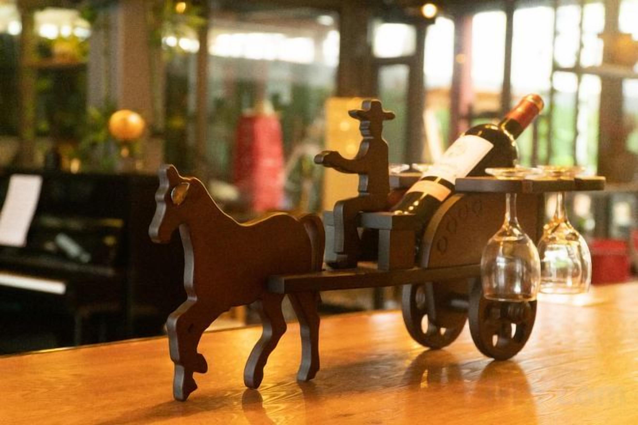 Un carruaje tirado por caballos de madera sobre una mesa de madera.