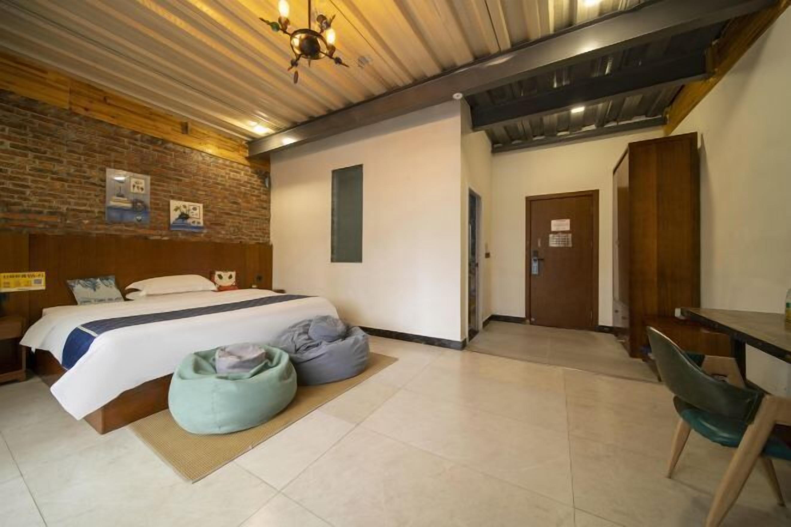 A bedroom with a bed, a desk, and a chair.