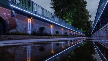 A canal with a bridge and a building with illuminated windows.