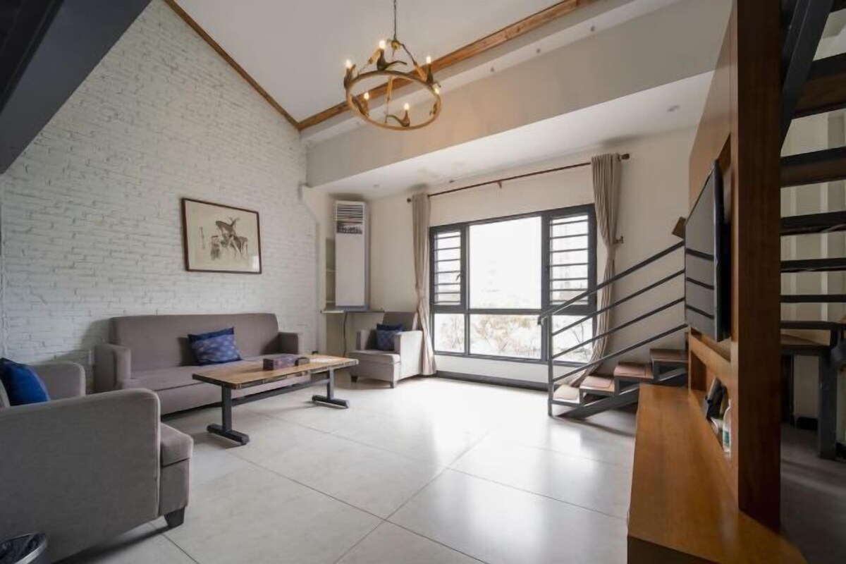 Una sala de estar moderna con un sofá, una mesa de centro y una escalera.