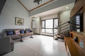 Una sala de estar moderna con un sofá, una mesa de centro y una escalera que lleva a un nivel superior.