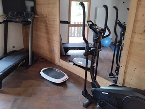 A home gym with a treadmill, elliptical, and stationary bike.