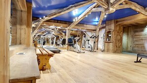 Une salle de sport avec des poutres en bois, du matériel d’exercice et un plancher en bois.