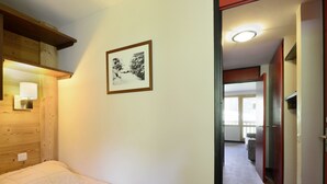 Een slaapkamer met een bed, een inlijsting foto aan de muur en een gang naar een badkamer.