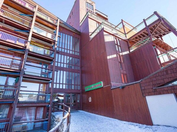 A multi-story wooden building with balconies and a sign reading "LES LAUZIERES".