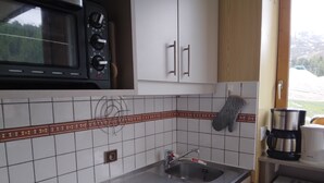 A compact kitchen with a stove, microwave, and sink. - Studio for 4, slopeside with balcony (Plagne Bellecôte)