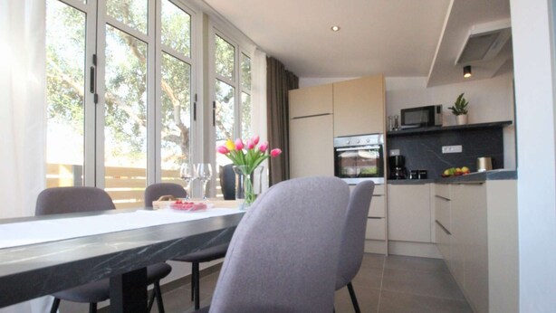 A modern kitchen with a dining area, large windows, and a view of the outdoors. - Apartment in Rovinjsko Selo for 6 persons (Rovinjsko Selo)