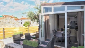A patio with wicker furniture, a table, and potted plants. - Apartment in Rovinjsko Selo for 6 persons (Rovinjsko Selo)