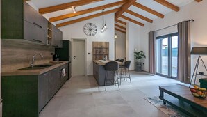 Una cocina amplia con vigas de madera, un comedor con vistas y un ventanal grande.