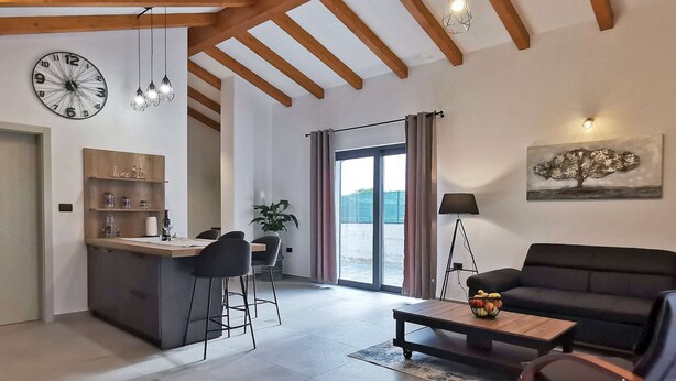 Una sala de estar moderna con un sofá, una mesa de centro y un comedor con barra.