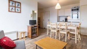 A modern apartment with a living room, dining area, and kitchen.