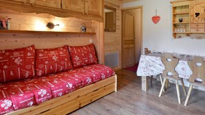 A cozy wooden room with a sofa, wooden cabinets, and a dining area. - Cozy studio at the slopes - Pets allowed (Belle Plagne)