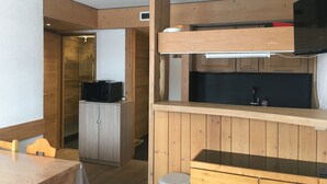 A compact kitchen with wooden cabinets, a microwave, and a sink.