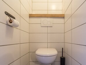 A small, clean bathroom with a toilet, a toilet paper holder, and a bidet. - Functional studio near shops and slopes, south-facing balcony, 4 people, non-smoking (La Rosière)
