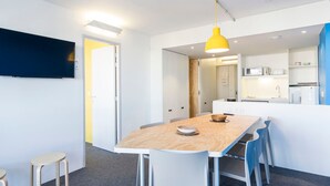 Une cuisine moderne avec des meubles blancs, un four à micro-ondes et un évier.