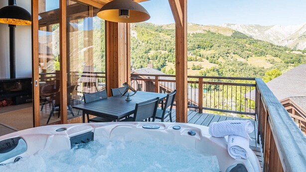 A wooden deck with a hot tub, outdoor seating, and a scenic mountain view. - Spacious chalet for 10 with sauna and jacuzzi (Saint-Martin-de-Belleville)
