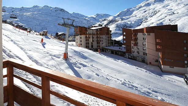 A snow-covered ski slope with buildings and a ski lift in the background. - Renovated 2-room apartment, ski-in/ski-out, southwest balcony (Les Menuires)