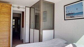 A bedroom with a bed, a wardrobe, and a window with blinds. - Bright ski-in/ski-out duplex, 8 pers., 3 bedrooms, Les Menuires (Les Menuires)