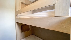 A bunk bed with a wooden frame and a mattress on the lower bunk. - Studio cabin at the slopes, pets allowed (Tignes)