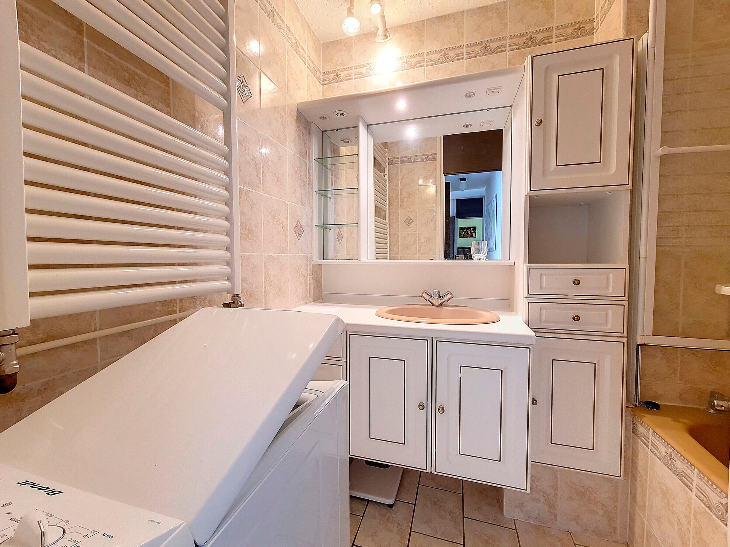Une salle de bain moderne avec une baignoire, un meuble-lavabo avec un miroir et une cabine de douche en verre.