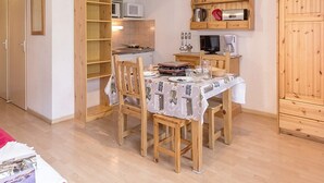A compact kitchen with wooden cabinets, a microwave, and a coffee maker. - Functional studio, ski-in/ski-out, balcony (Les Menuires)