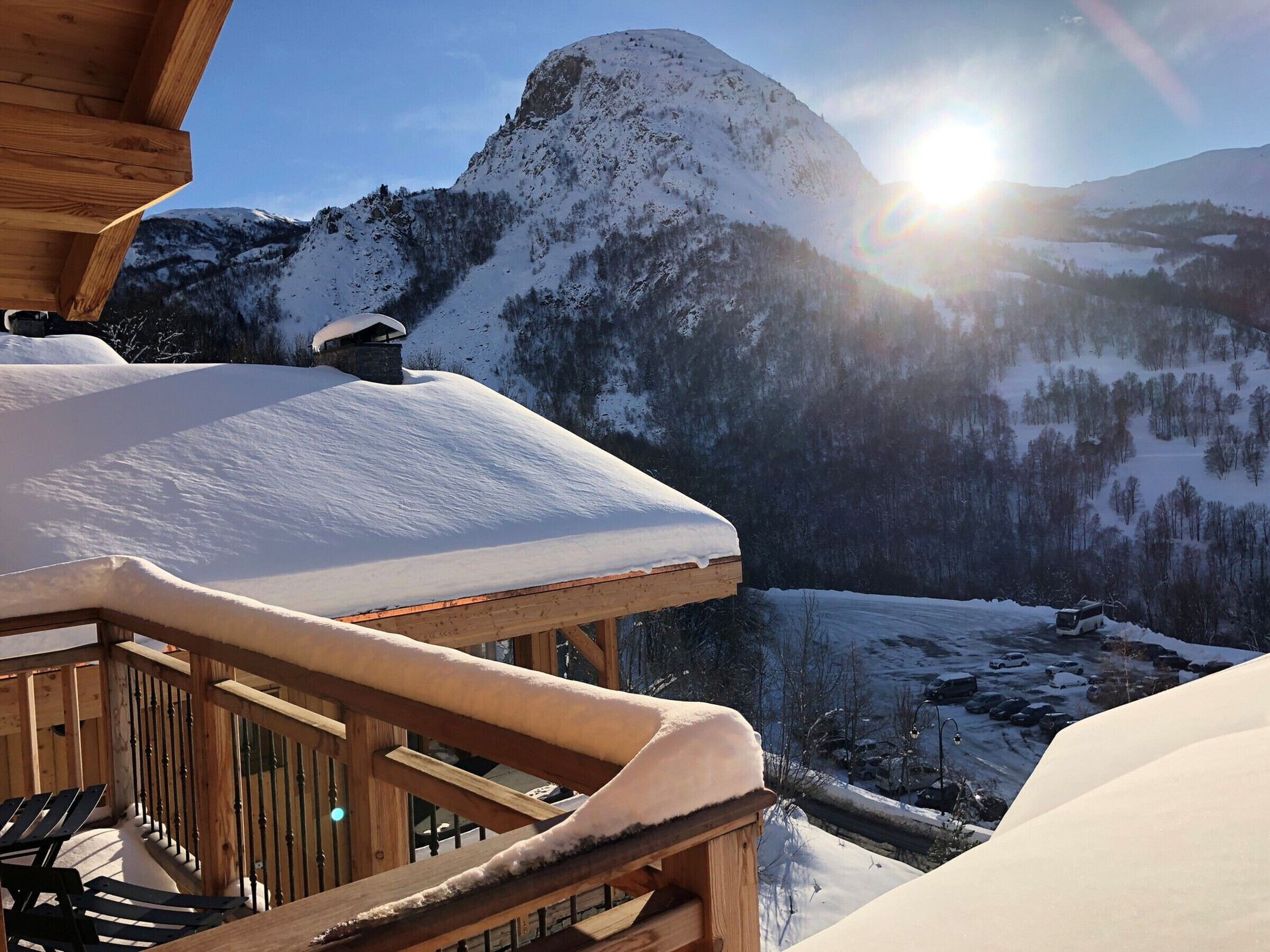 Una cabaña de madera con balcón que domina un paisaje montañoso nevado.