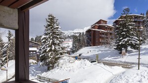 A snowy mountain resort with buildings and a ski lift.