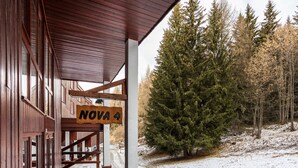 A wooden building with a sign reading "NOVA 4" and a snow-covered ground.
