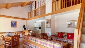 A multi-level living space with wooden floors, a dining area, a kitchen, and a loft bedroom. - Spacious Duplex 8 pers · Ski-in/Ski-out · Balcony (Saint-Martin-de-Belleville)