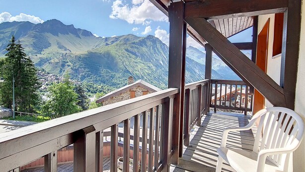 A wooden balcony with a view of mountains and a town below. - Spacious Duplex 8 pers · Ski-in/Ski-out · Balcony (Saint-Martin-de-Belleville)