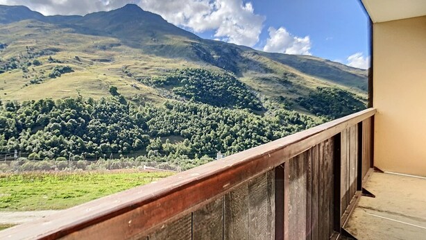 A balcony with a view of a mountain and forest.