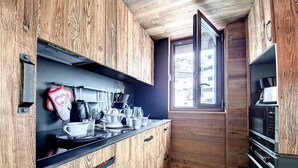 A compact kitchen with wooden cabinets, a black countertop, and a window providing natural light.