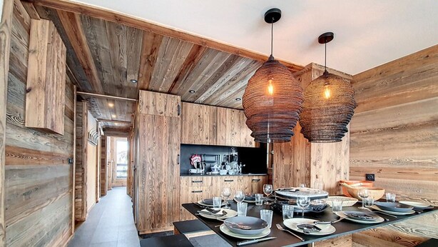 A modern kitchen with wooden walls and a central island.