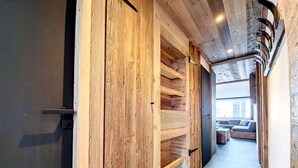A hallway with wooden shelving units and a seating area with a view of the city.