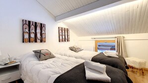 Une chambre d’hôtel avec deux lits, un bureau et une fenêtre avec des rideaux.