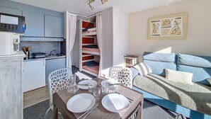 Um espaço compacto com cozinha compacta, área de refeições e cama.