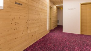 A hallway with wooden panel walls, a red carpet, and a sign indicating room number 012 013. - Renovated studio at slopes, balcony, sleeps 4, Les Menuires (Les Menuires)