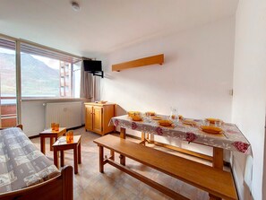 Enjoy meals in the dining area with a table for four, a flat-screen TV, and a view of the surrounding mountains.