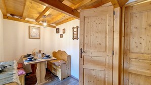 A wooden interior with a dining table, benches, and a door. - 2-room apartment at the foot of the slopes, village center (Saint-Martin-de-Belleville)