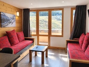 Ein gemütliches Zimmer mit Holzvertäfelung, einer Couch, einem kleinen Tisch und einem Bild an der Wand.